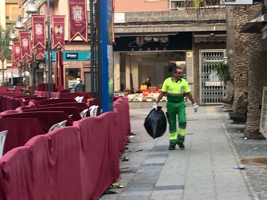 Operario del servicio de limpieza de Motril retira la basura de la Plaza de las Palmeras