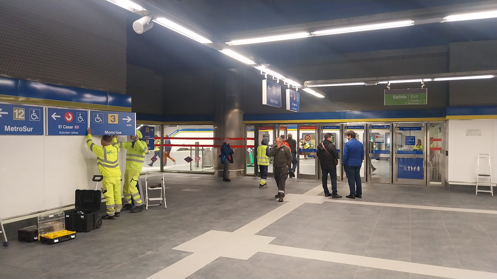 Operarios colocando cartelería poco antes de la inauguración de la ampliación de la L3 a El Casar