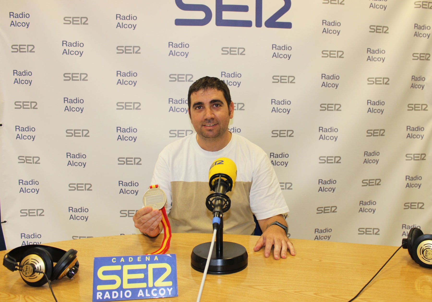 Carlos Escuder, en el estudio central de Radio Alcoy, muestra su medalla de plata del Nacional