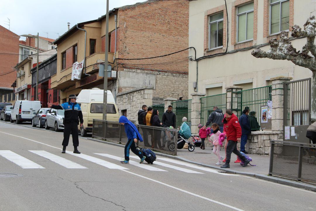 Un agente de Policía Local regula el tráfico a la salida del colegio La Villa en Cuéllar