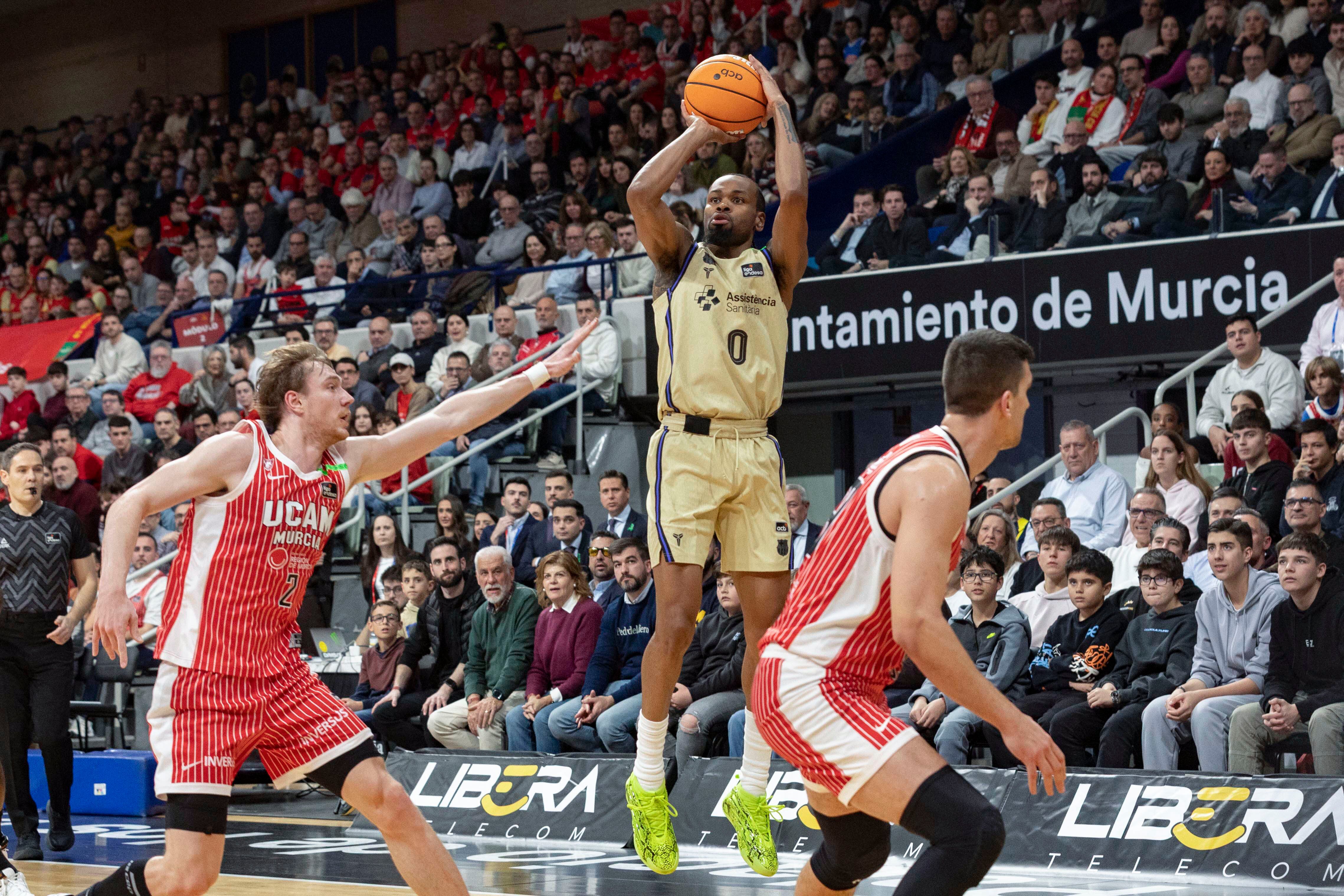 El escolta estadounidense del FC Barcelona Kevin Punter lanza a canasta ante la presión del alero de UCAM Sander Raieste.