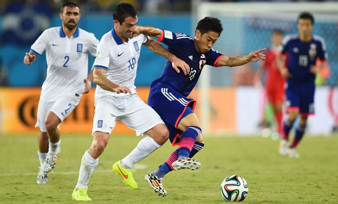 Giorgos Karagounis intenta pelear una pelota con Shinji Kagawa durante el partido entre Grecia y Japón de la segunda jornada del grupo C del Mundial de Brasil.