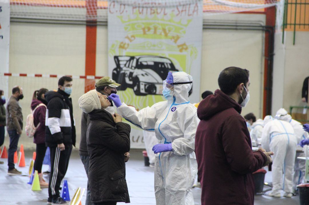 Un sanitario realiza un test a una vecina en el cribado realizado hoy en Cuéllar en la primera jornada