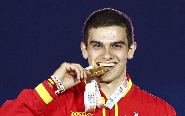 El atleta español, Bruno Hortelano, muerde la medalla de oro en el pódium de Ámsterdam.