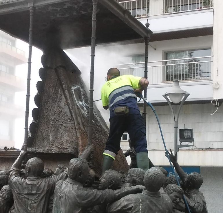 Operario retirando la pintura del monumento