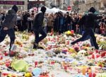 BRUSSELS, BELGIUM - MARCH 27: Right-wing self-described hooligans trample over flowers and candles left over the previous few days at Place de la Bourse for victims of simultaneous suicide bombings at Brussels Zaventem airport and Maelbeek/Maalbeek train 