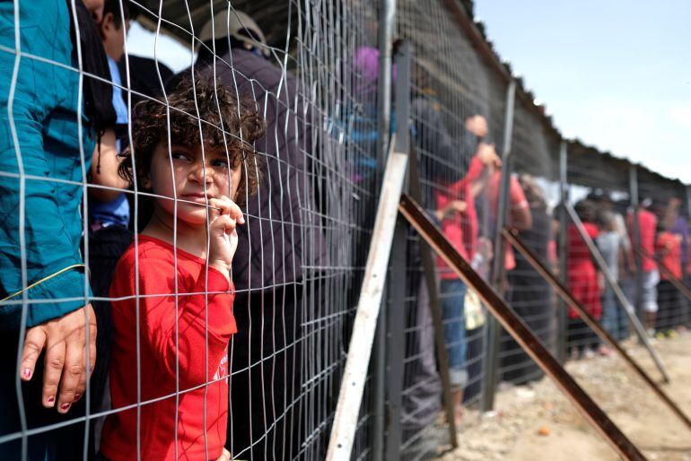 Una niña hace cola para comida en un campamento improvisado para los migrantes y refugiados en la frontera entre Grecia y Macedonia, cerca de la localidad de Idomeni.