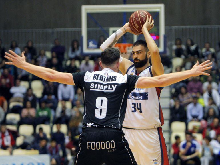 El jugador del Bilbao Basket, Dairis Bertans (de espaldas), defiende el ataque del nuevo jugador del Obradoiro el alero Kostas Vasileiadis, durante el encuentro de la jornada 31 de la Liga ACB que se celebró en el Multiusos de Sar de Santiago de Compostel