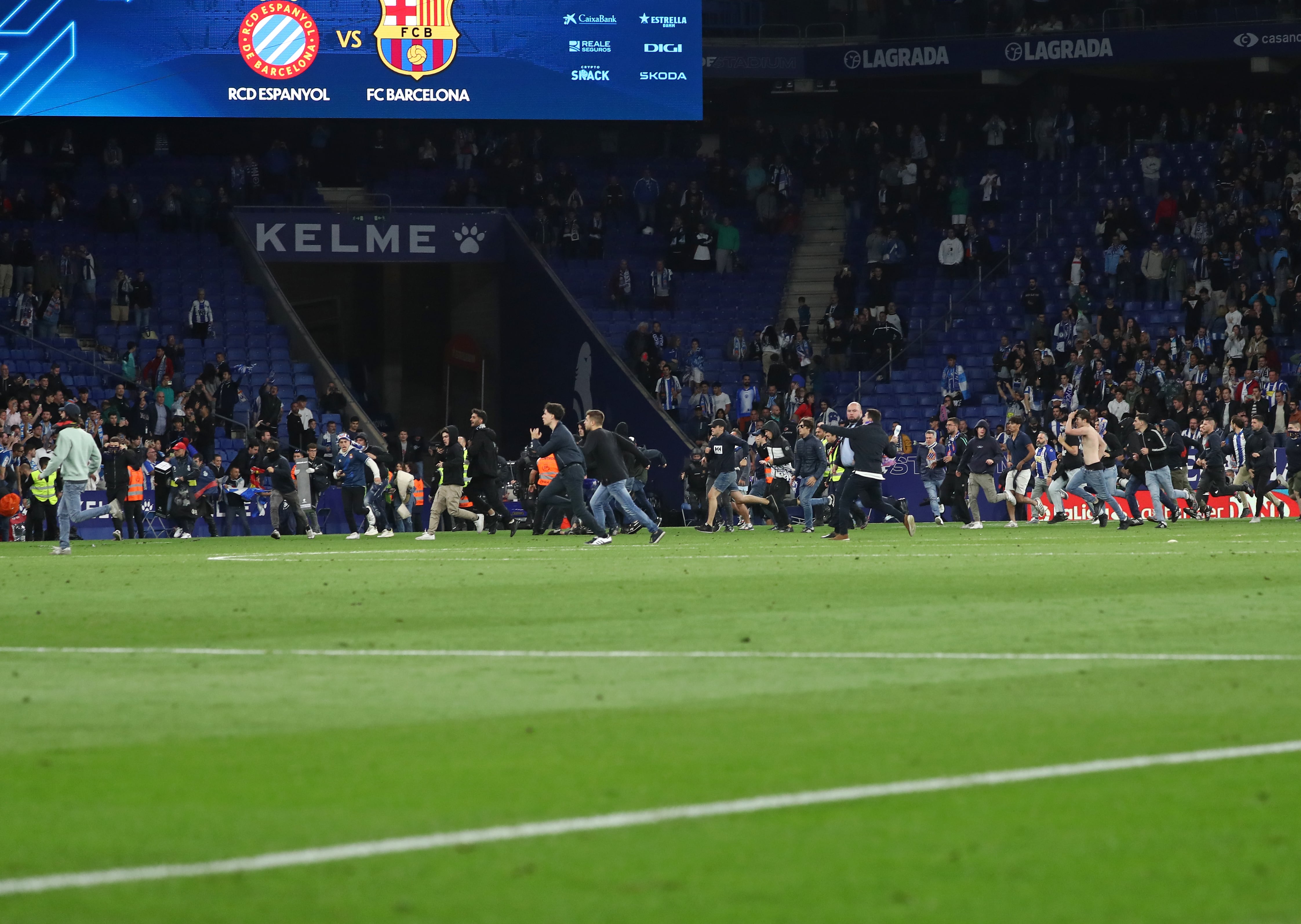 Aficionados radicales del Espanyol saltan al campo durante la celebración del FC Barcelona