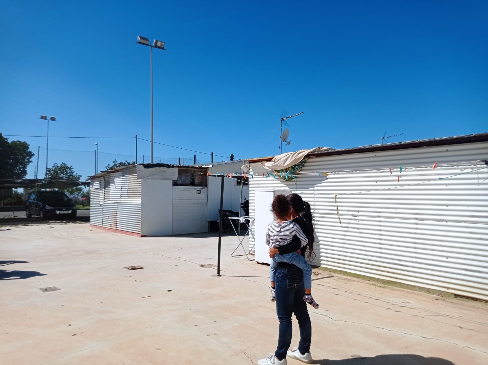 Una madre con su hija en junto a su vivienda prefabricada de Lorca