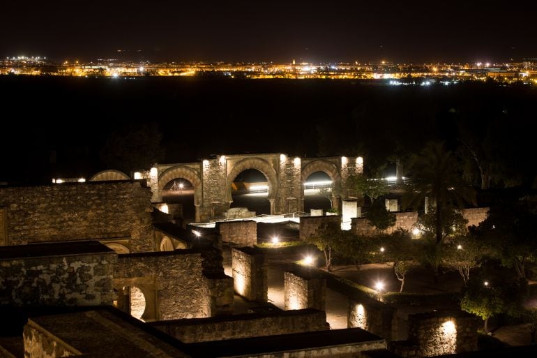 La ciudad califal de Medina Azahara, con su iluminación nocturna y al fondo la ciudad de Córdoba.