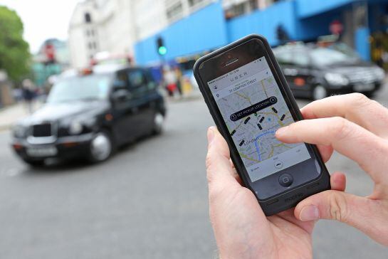 A user scans for an available vehicle using the Uber Technologies Inc.&#039;s app on an Apple Inc. iPhone 5 smartphone in this arranged photograph in London, U.K., on Friday, May 30, 2014. London&#039;s taxis are planning a 10,000-cab protest next month, as profess