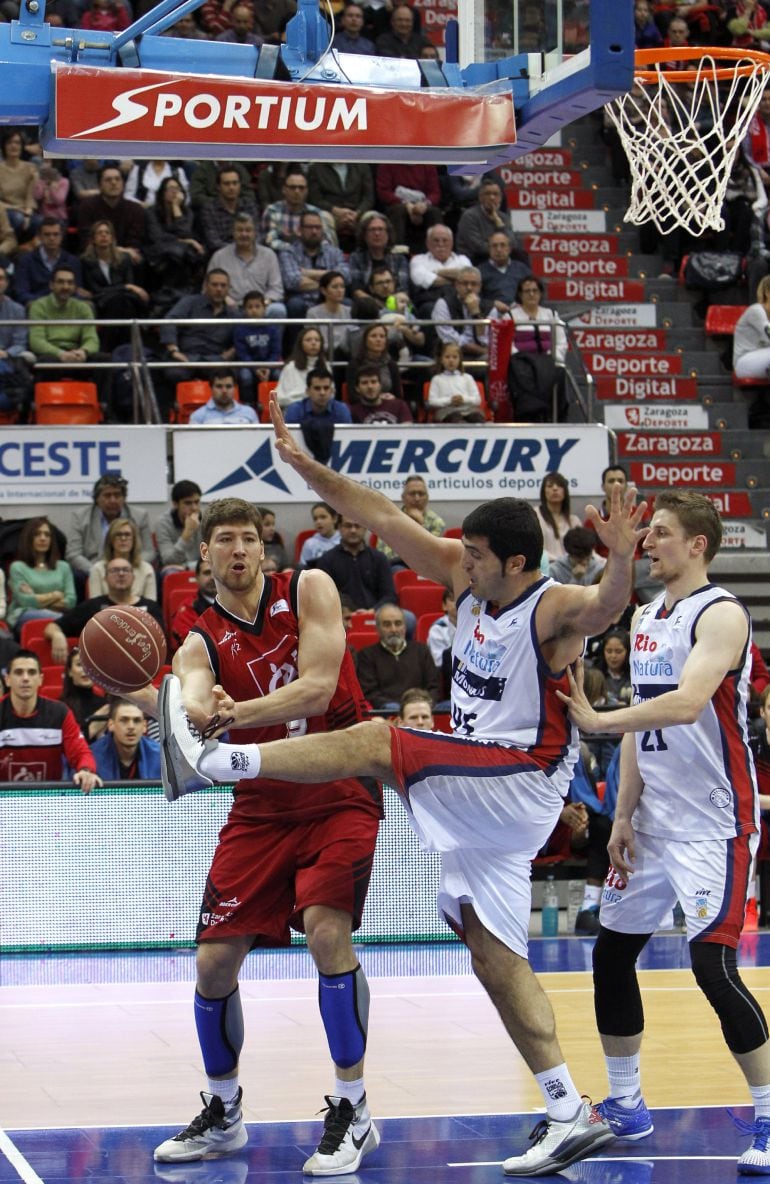 El jugador del Rio Natura Monbus Obradoiro Jesús Chagoyen (c) intenta impedir el pase de la pelota a Viacheslav Kravtsov, del CAI Zaragoza, durante el partido disputado entre ambos conjuntos, correspondiente a la 24ª jornada de la Liga Endesa.