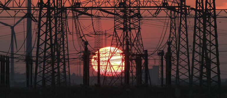 En la imagen, una puesta de sol junto al tendido eléctrico y unos molinos de viento. EFE/Archivo