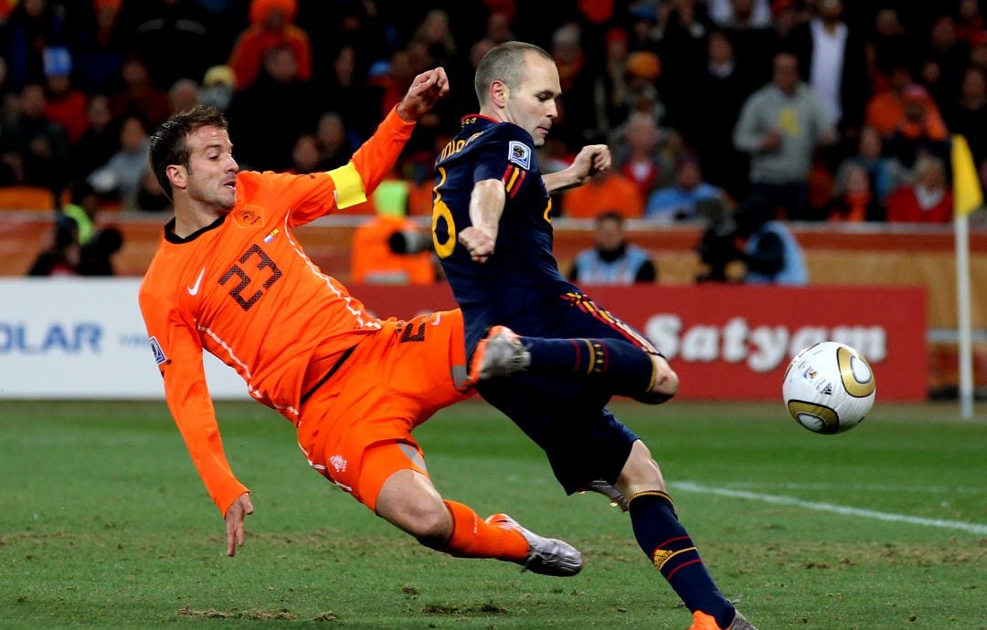 Van der Vaart intenta blocar ante Iniesta el disparo que nos hizo campeones del mundo en 2010