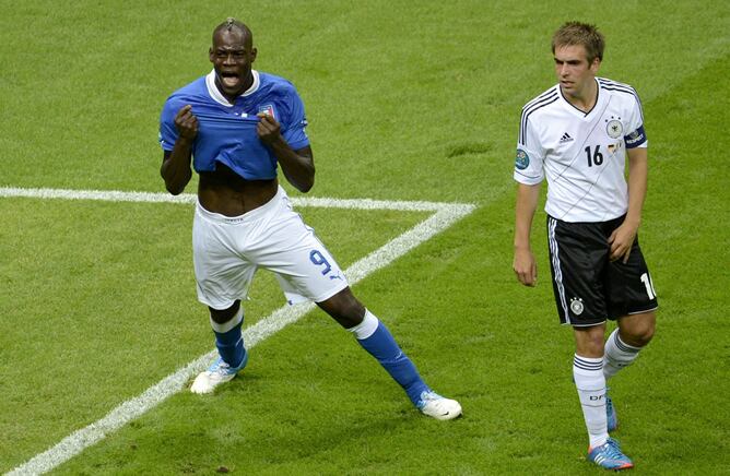 El delantero italiano Mario Balotelli celebra su gol contra Alemania ante la desolación del alemán Philipp Lahm, durante la semifinal de la Eurocopa 2012 entre las selecciones de Alemania e Italia, el día 28 de junio de 2012 en Varsovia, Polonia.