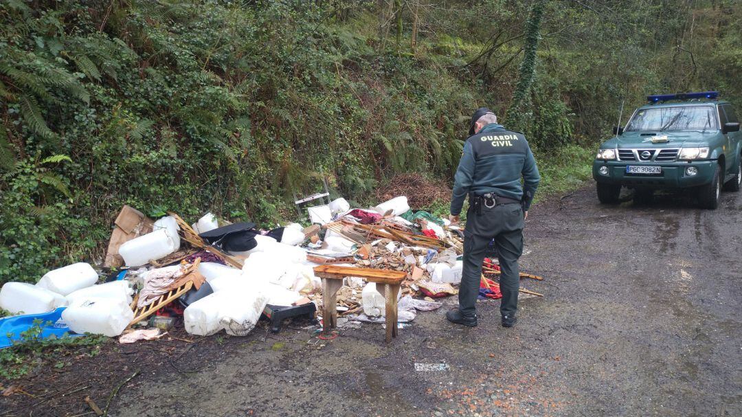 Un agente de la Guardia Civil junto al vertido de basura