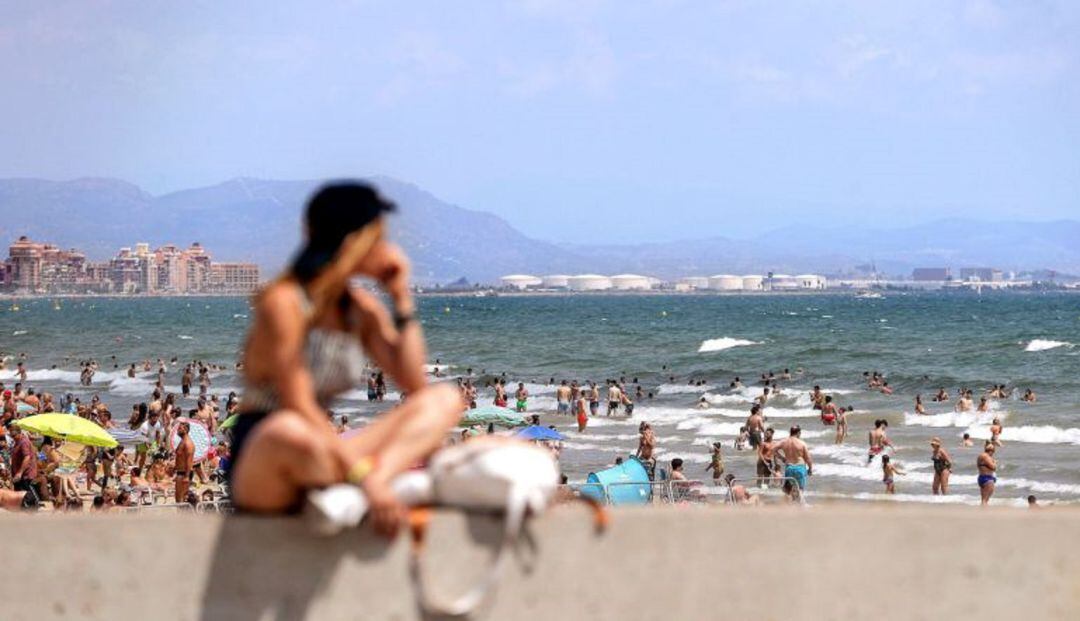 Una joven observa las repletas playas de Las Arenas y La Malvarrosa de València