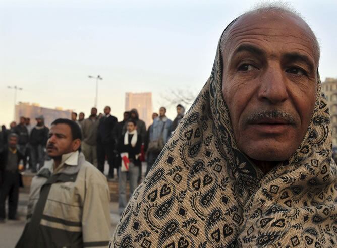 Un hombre se protege del frío tras despertarse en la plaza Tahrir de El Cairo