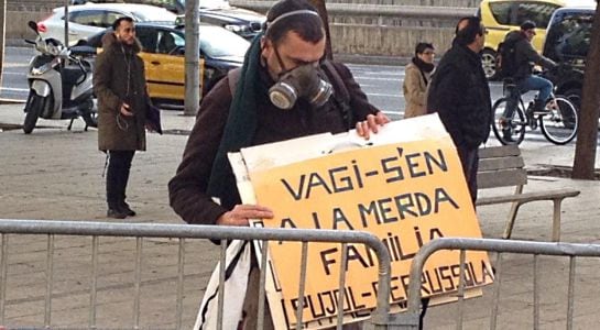 Una ciudadano protesta a las afueras de la Ciudad de la Justicia de Barcelona con una pancarta que dice &quot;Váyase a la mierda, familia Pujol Ferrusola&quot;