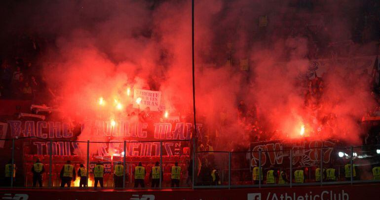 Seguidores del Olympique de Lyon encienden y arrojan bengalas durante el partido de San Mamés