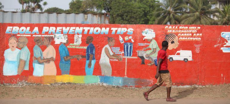 MNR03. Monrovia (Liberia), 22/03/2015.- A Liberian man walk pass an ebola awareness painting on a wall in downtown Monrovia, Liberia, 22 March 2015. Liberia has confirmed a new case of Ebola, undermining growing hopes in the country that it might soon be 