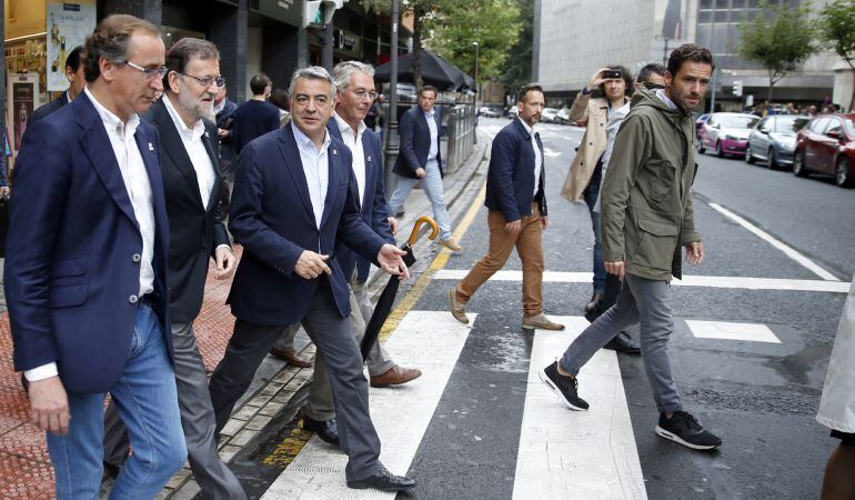 El presidente del Gobierno en funciones, Mariano Rajoy (2i), y el candidato del PP a lehendakari, Alfonso Alonso (i), se dirigen por las calles de la capital vizcaína a un mitin electoral. 