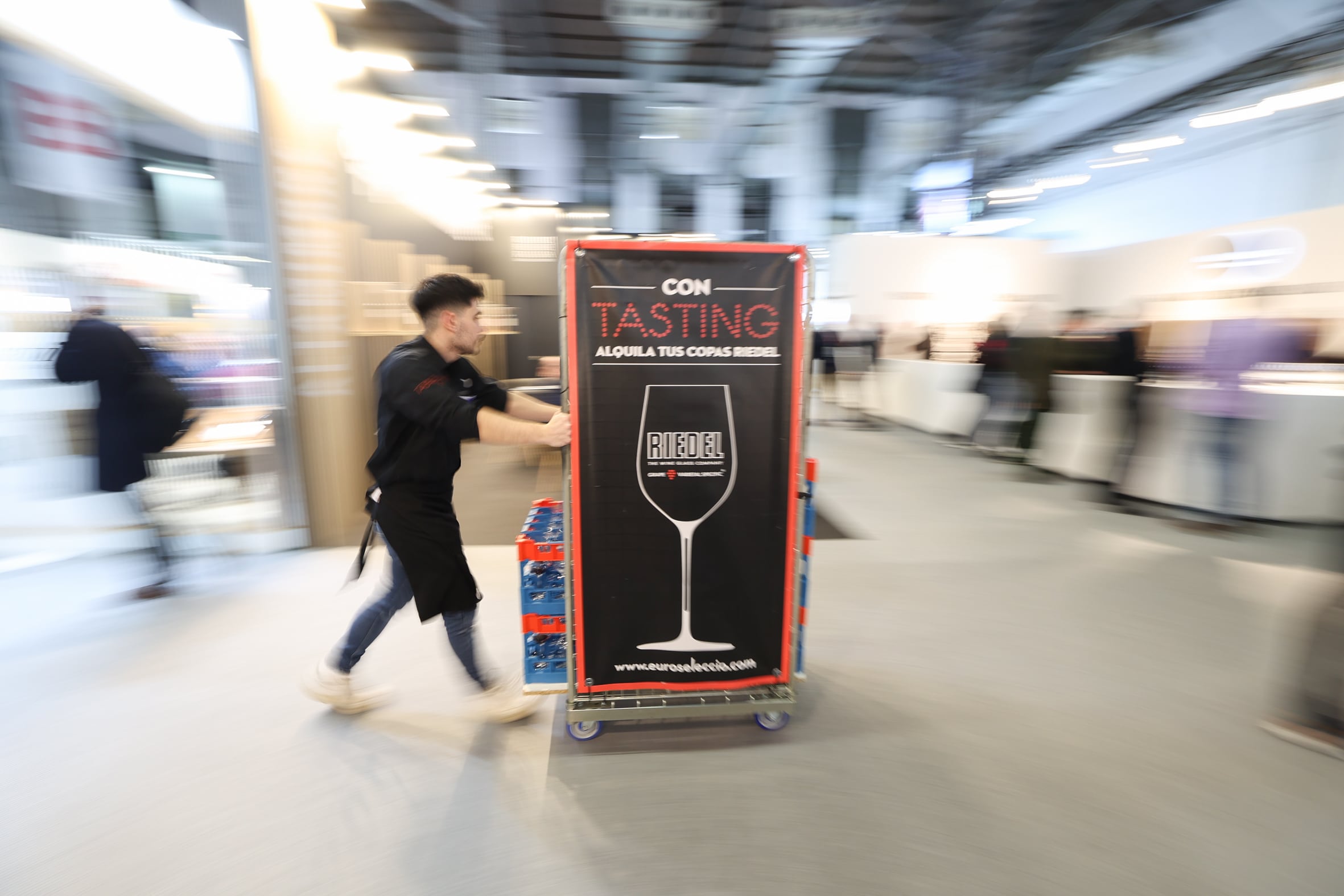 Trajín de carritos llenos de copas limpias en la barcelona Wine Week.