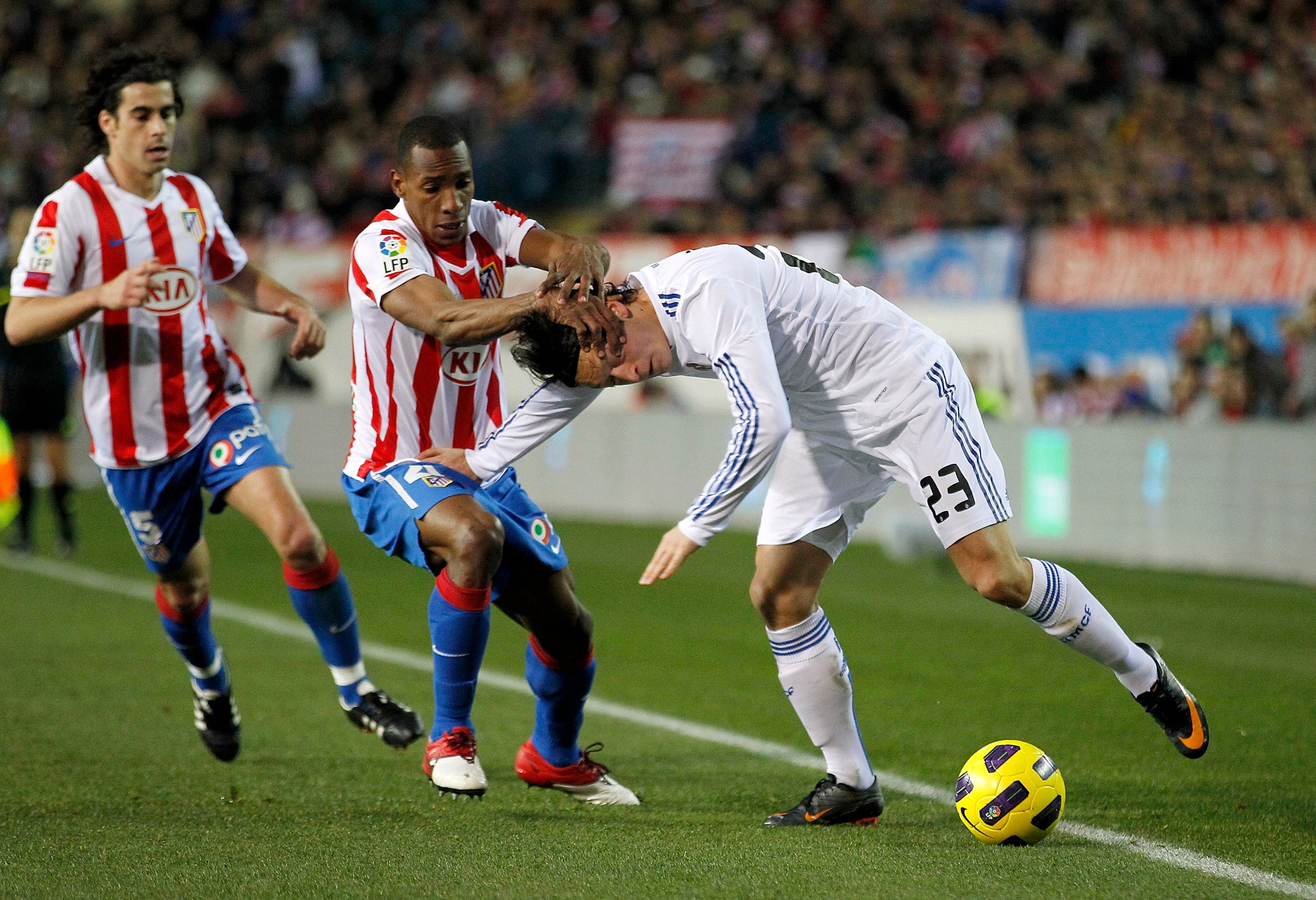 Mesut Ozil y Luis Amaranto Perea, durante un derbi madrileño.  (Ángel Martinez/Real Madrid via Getty Images)