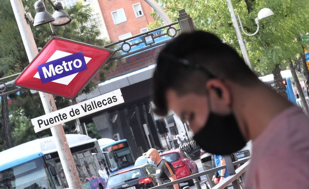 (ARCHIVO) Vecinos pasean al lado del metro de Puente de Vallecas, una de las estaciones que cerrará por obras