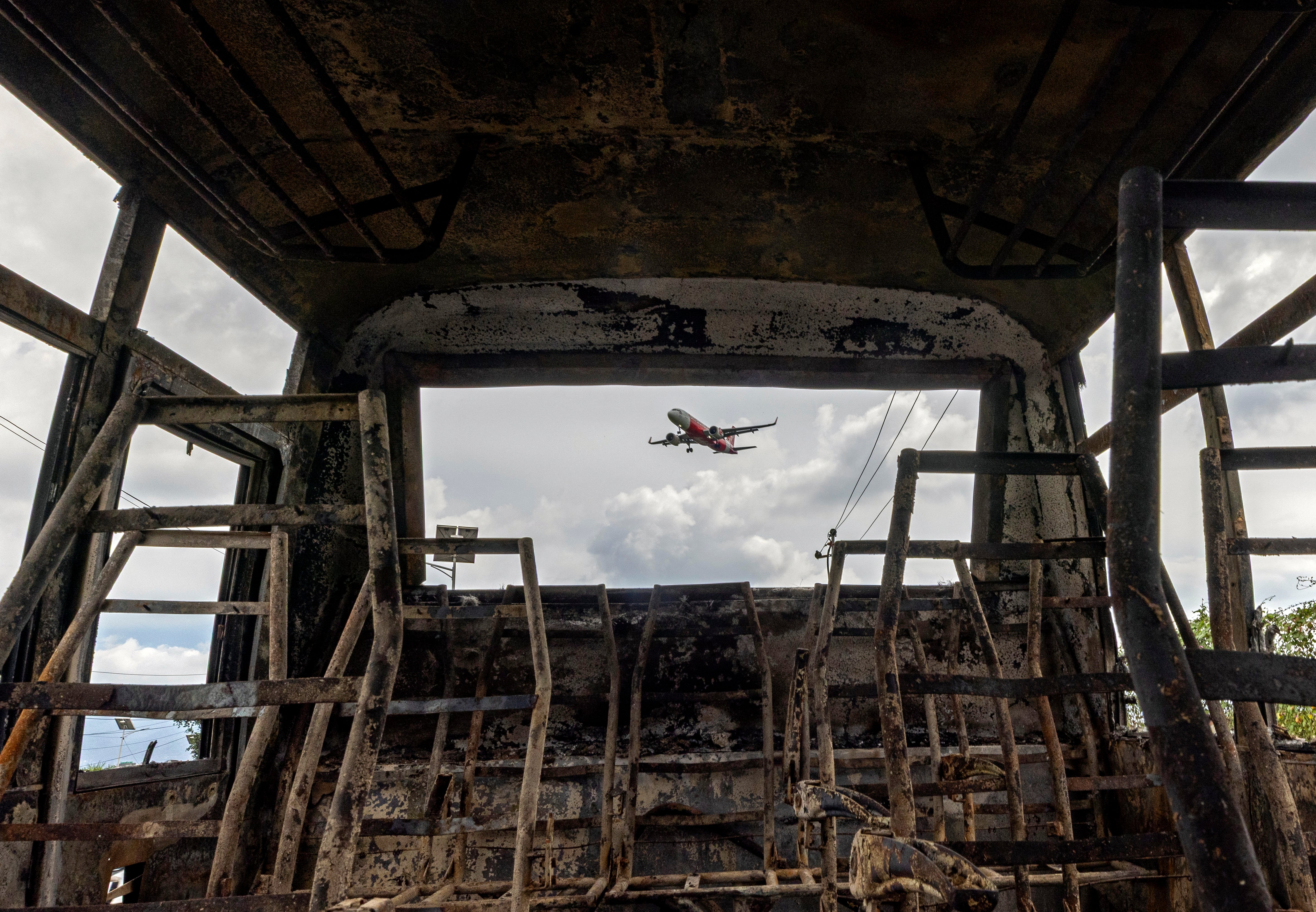 Kathmandu (Nepal), 11/09/2025.- A view of a plane from the carcass of a burn vehicle near the international airport in Kathmandu, Nepal, 11 September 2025. The Kathmandu International Airport resumed operations after closing amid protests that began on 8 September. The riots, led by a group of youths identifying as Generation Z, were against corruption and a government-imposed social media ban, which resulted in at least 19 deaths. (Protestas, Disturbios) EFE/EPA/NARENDRA SHRESTHA 95868