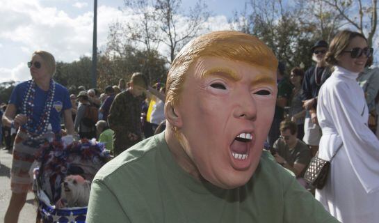 A man wearing a mask depicting U.S. Republican presidential candidate Donald Trump takes part in the Mystic Krewe of Barkus dog parade in the French Quarter of New Orleans, Louisiana January 31, 2016. REUTERS/Lee Celano