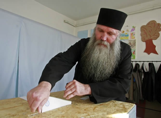 Un monje deposita su voto en Bucarest