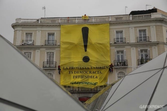 Greenpeace despliega una pancarta en la Puerta del Sol para reivindicar la protesta ciudadana