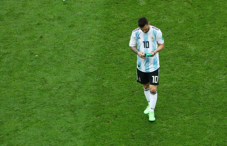 Messi, cabizbajo, con el brazalete de capitán en la mano, al final del partido