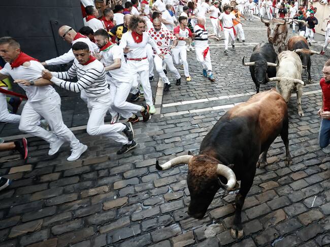 Los toros de la ganadería de Fuente Ymbro a su paso por la curva de Mercaderes durante el cuarto encierro de los sanfermines 2023