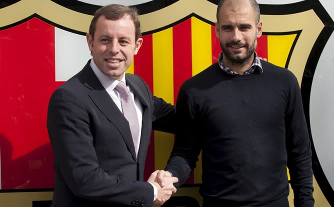 El presidente del F.C. Barcelona, Sandro Rosell, estrecha la mano del entrenador Josep Guardiola, tras la firma del contrato por el que el técnico azulgrana será una temporada más el responsable del primer equipo