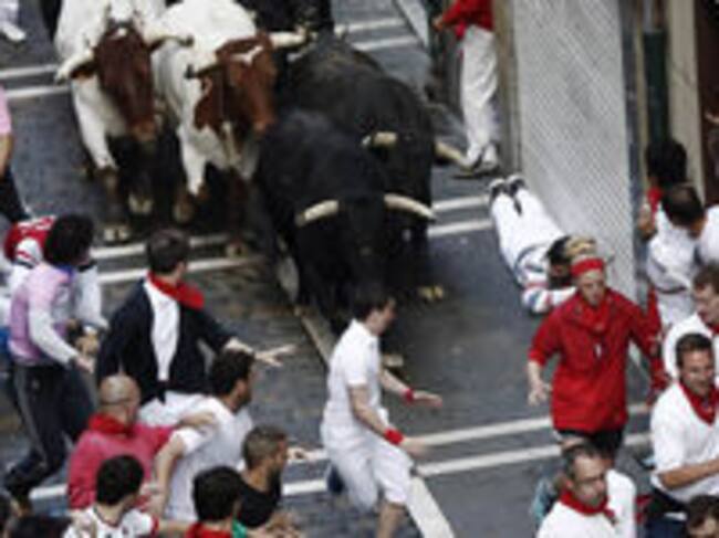 Varios mozos corren ante los toros de la ganadería extremeña de Jandilla, ausentes desde el año 2010 de la feria del toro de Pamplona