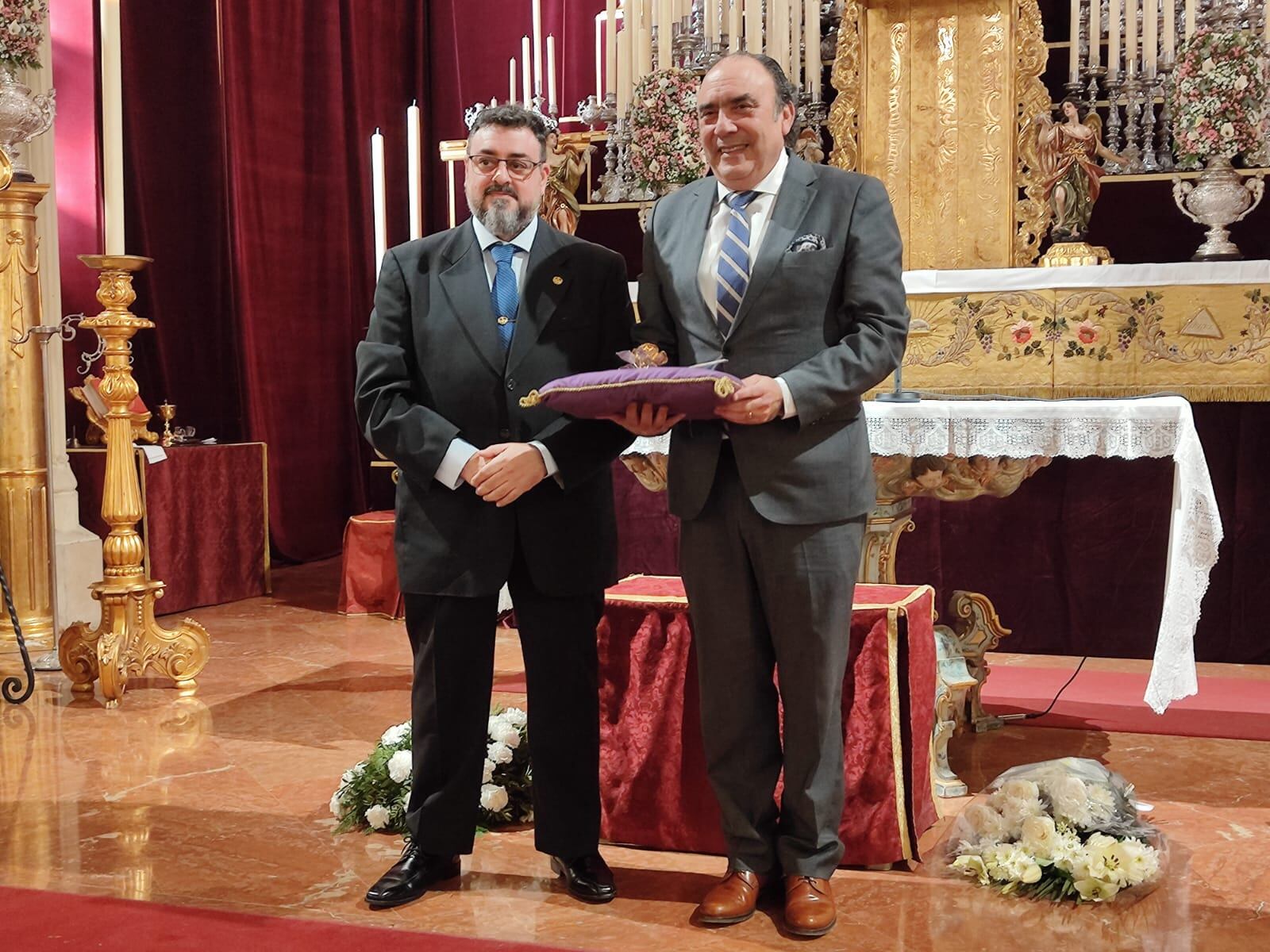 El hermano mayor de Los Gitanos, José María Flores -derecha-, recibe de manos de su homólogo en la Vera Cruz de Utrera, Juan Luis Espinosa, la Rosa de Pasión de Cruz de Guía a los Donantes de Órganos