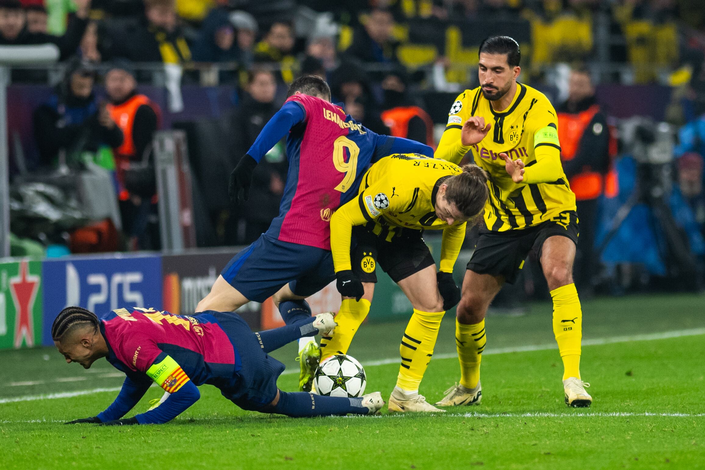 Futbolistas de Borussia Dortmund y FC Barcelona disputan un balón en el partido de la fase de liga de la UEFA Champions League