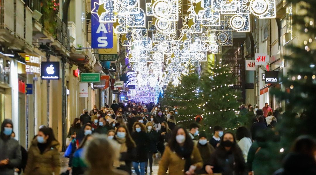 Gente paseando por las calles de Vigo, decoradas con motivos navideños