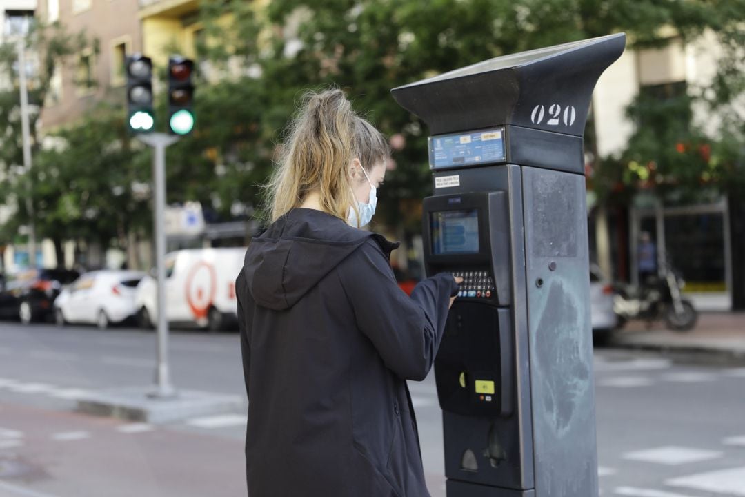 Una joven utiliza un parquímetro del Servicio de Estacionamiento Regulado (SER) de Madrid. Archivo.