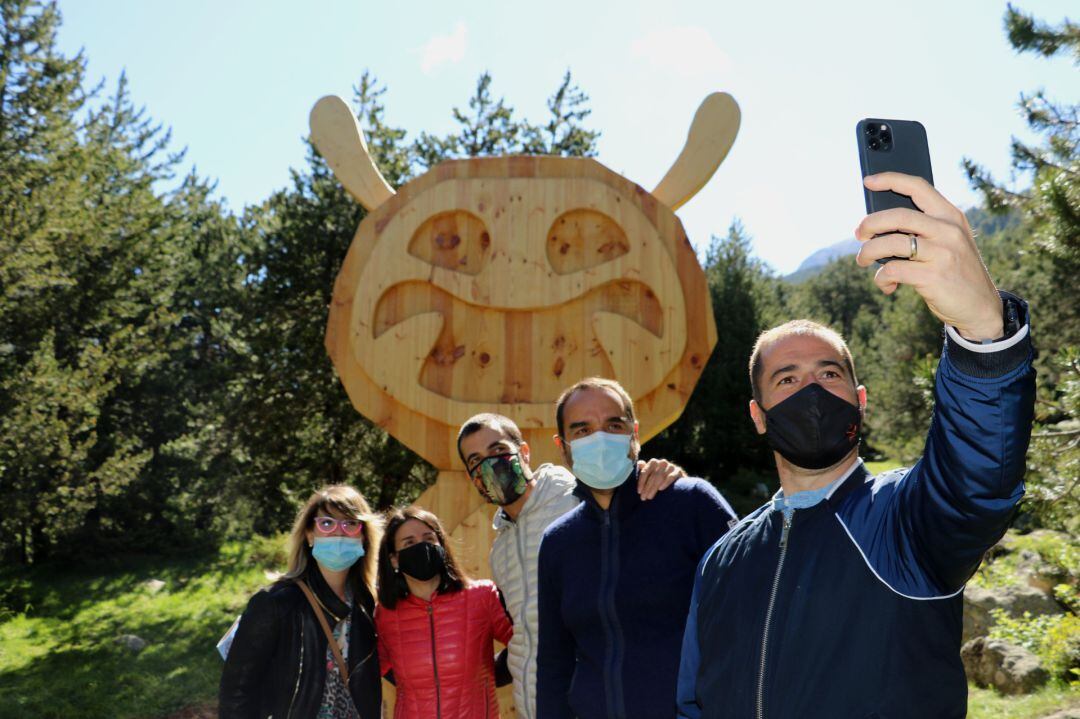 Alguns dels consellers de cultura de diverses parròquies, amb la cònsol major d'Encamp, Laura Mas, es fotografien al costat d'una de les escultures del tamarro que conformen la ruta familiar.