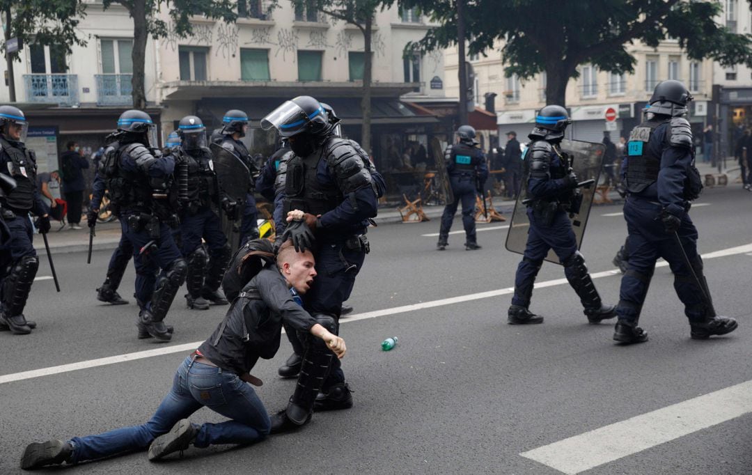 Un policía francés deteniendo a uno de los protestantes en París