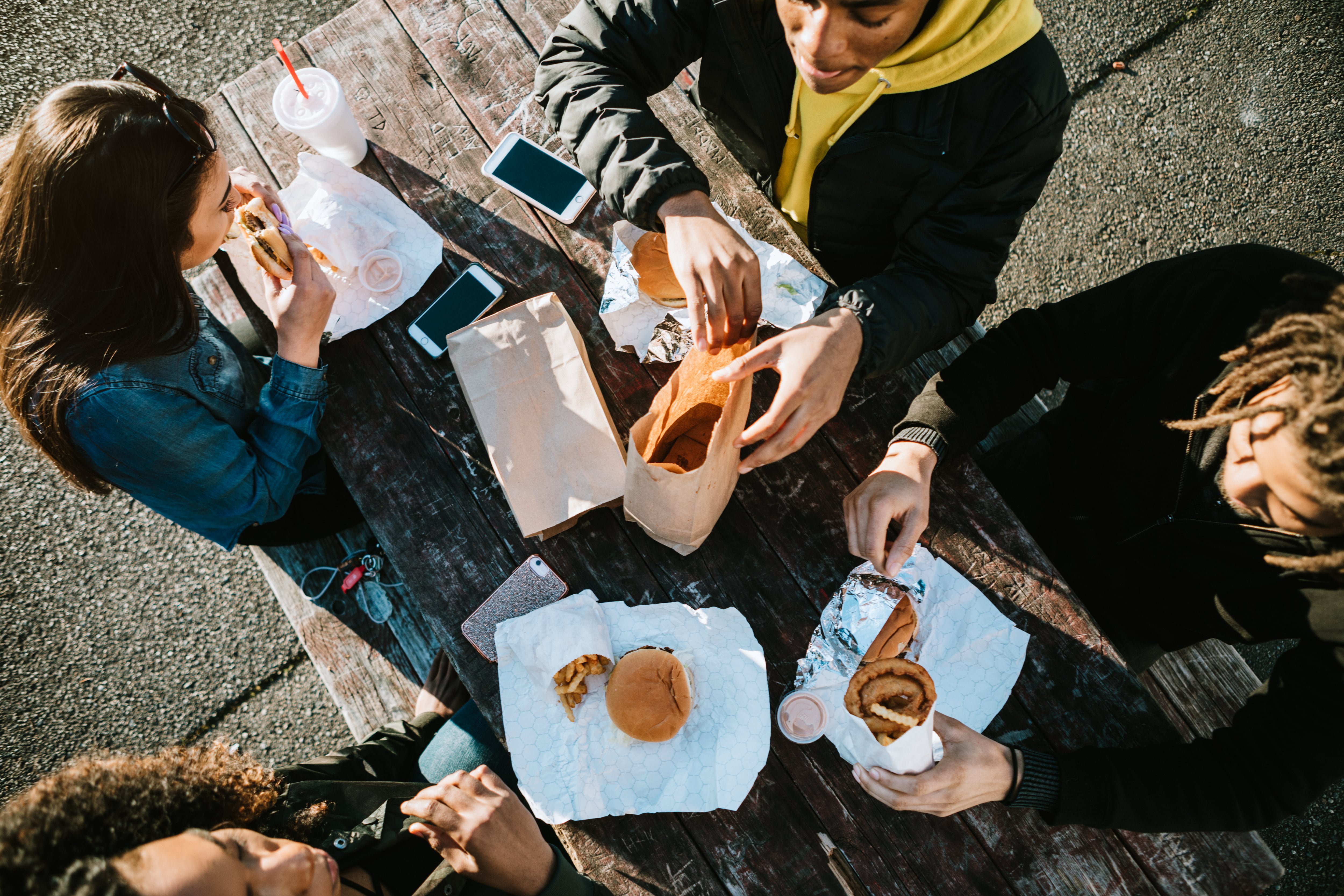 Jóvenes consumiendo alimentos ultraprocesados.