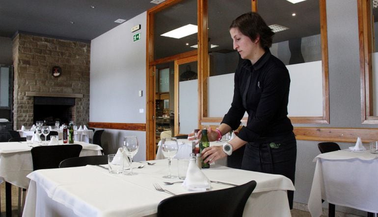 Una cambrera preparant una taula.