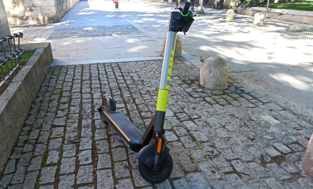 Patinete situado en la acera en el casco histórico de Alcalá de Henares. 