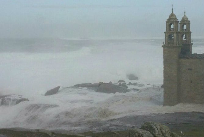 El mar baña el Santuario de la Barca en Muxía (A Coruña)