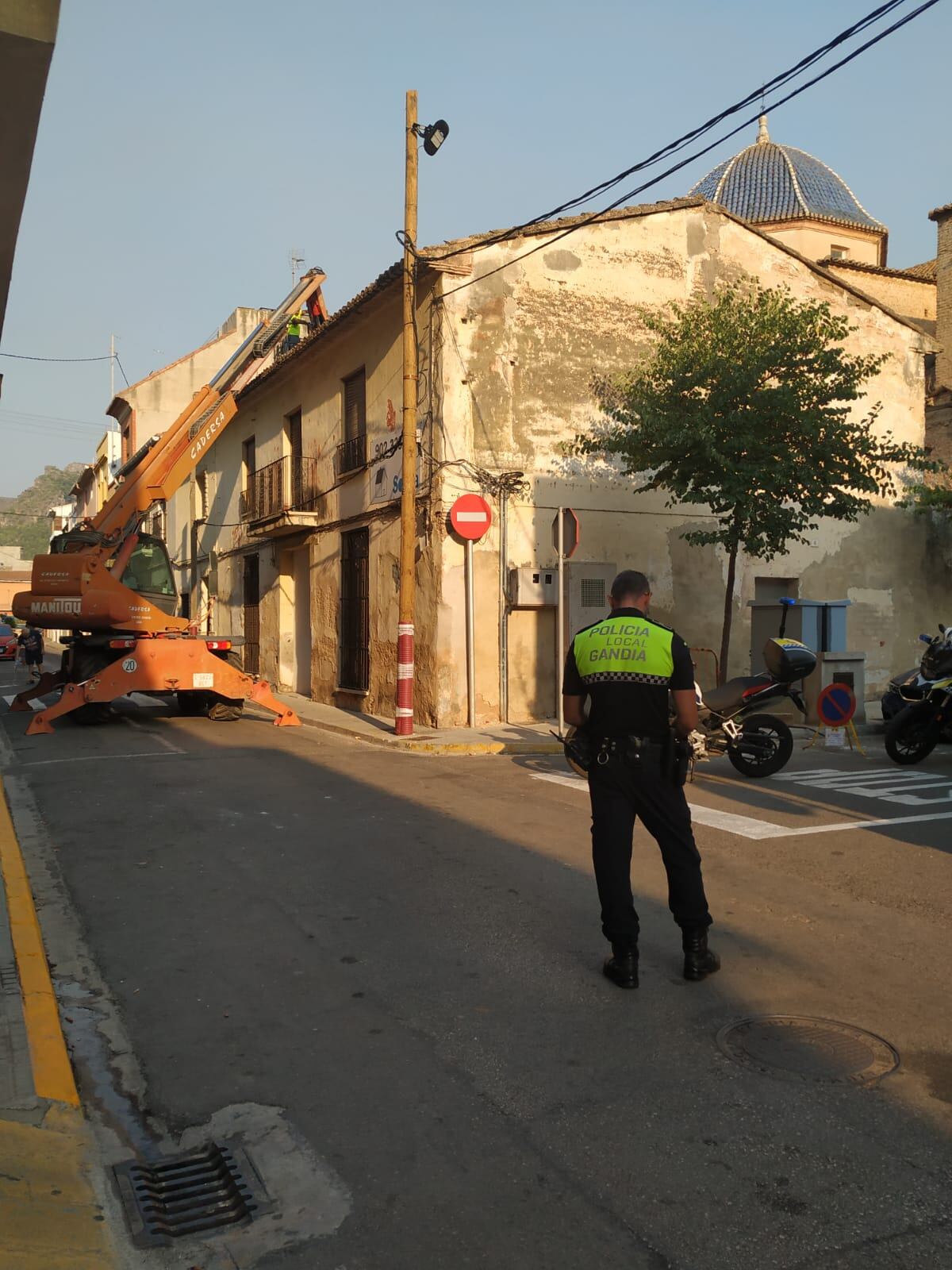 Unos operarios comienzan con el derribo de la vivienda situada junto a la iglesia de Beniopa.