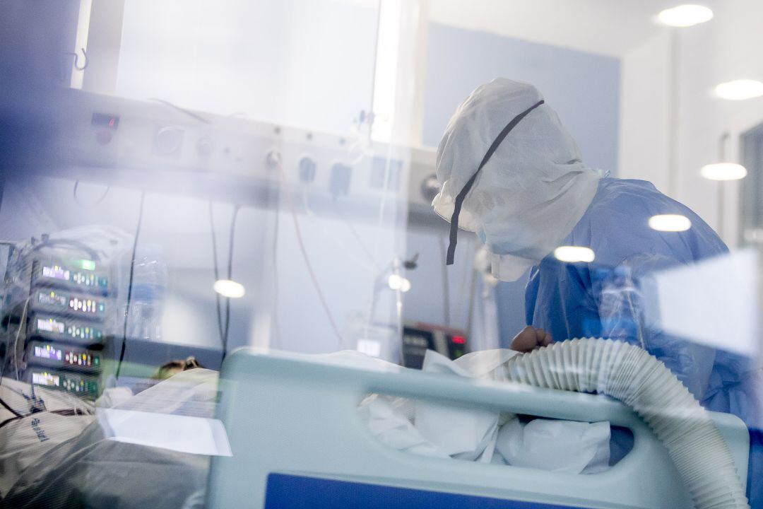 Personal sanitario atendiendo a un paciente de COVID-19 en la UCI.